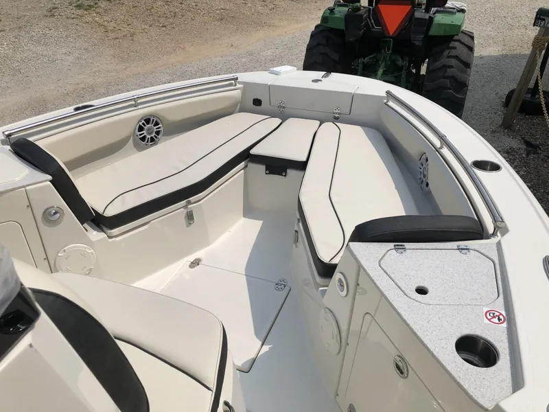 Slide: The Image of 2024 Stingray 216 CC boat interior with cushioned seating and storage compartments. - 10