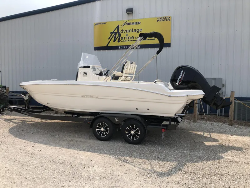 Slide: The Image of 2024 Stingray 216 CC boat on a trailer outside a marine dealership. - 3