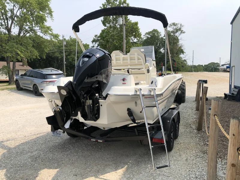 Slide: The Image of 2024 Stingray 216 CC boat on trailer with outboard motor and ladder. - 6