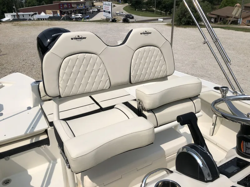 Slide: The Image of 2024 Stingray 216 CC boat with dual cushioned seats and steering console. - 8