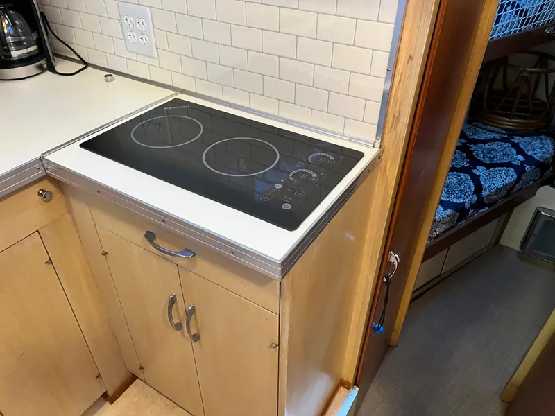 Slide: The Image of 1962 Chris-Craft Constellation kitchen with modern stovetop and wooden cabinetry. - 11