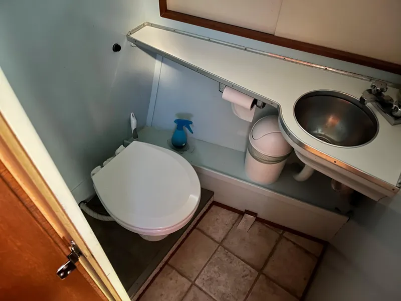 Slide: The Image of 1962 Chris-Craft Constellation bathroom with toilet, sink, and tiled floor. - 15