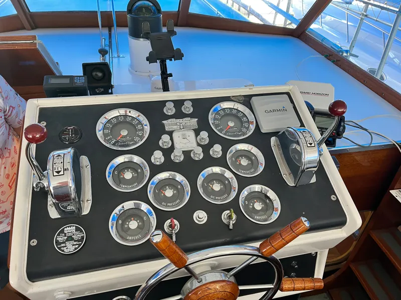 Slide: The Image of Vintage 1962 Chris-Craft Constellation boat dashboard with gauges and wooden steering wheel. - 2