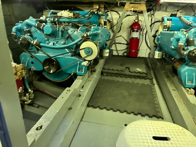 Slide: The Image of Engine room of a 1962 Chris-Craft Constellation boat with blue engines and fire extinguisher. - 23