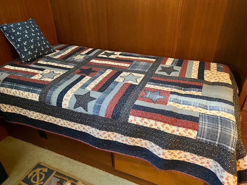 Slide: The Image of Single bed with a patriotic quilt and anchor-themed pillow on a 1962 Chris-Craft Constellation. - 25
