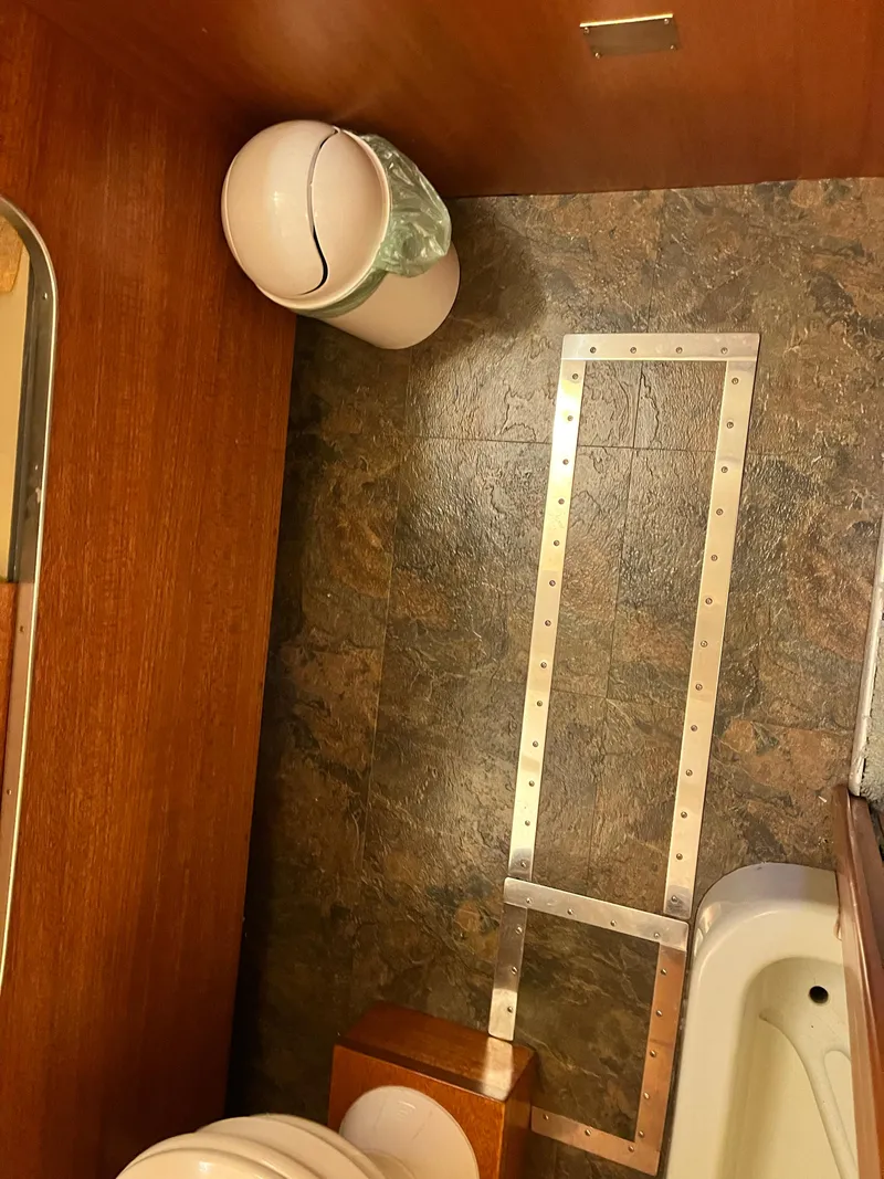 Slide: The Image of 1962 Chris-Craft Constellation bathroom interior with wood paneling and tiled floor. - 29