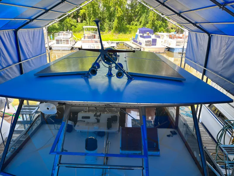Slide: The Image of 1962 Chris-Craft Constellation boat docked under a canopy with other boats nearby. - 32