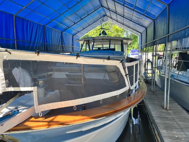 Slide: The Image of 1962 Chris-Craft Constellation boat docked under a blue canopy. - 38