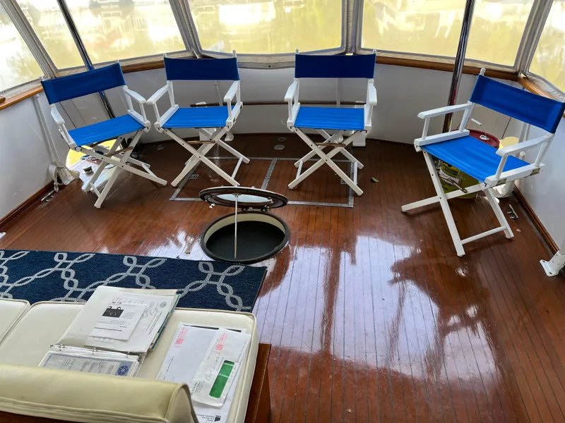 Slide: The Image of Interior of 1962 Chris-Craft Constellation with blue director chairs and wooden flooring. - 4