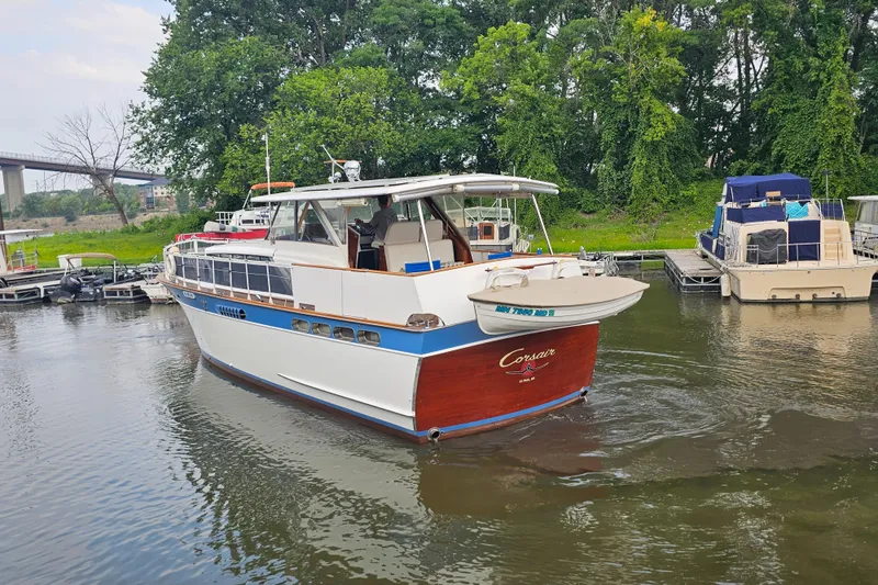 Slide: The Image of 1962 Chris-Craft Constellation boat docked on a calm river with lush greenery. - 42