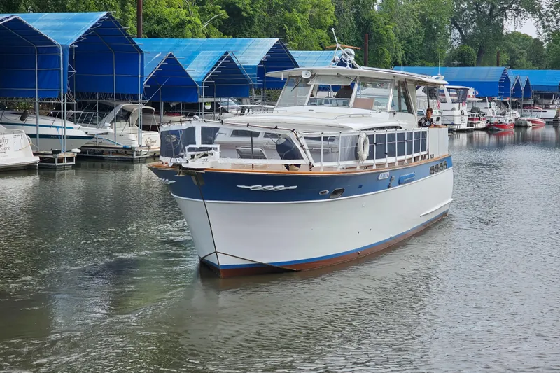 Slide: The Image of 1962 Chris-Craft Constellation boat docked in a marina with blue canopies. - 45