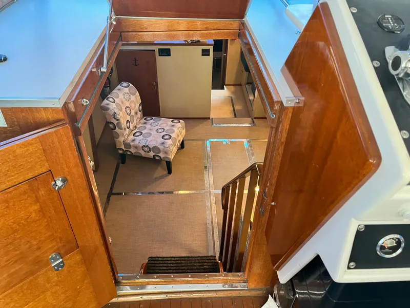 Slide: The Image of 1962 Chris-Craft Constellation interior with wooden stairs, patterned chair, and carpeted flooring. - 5
