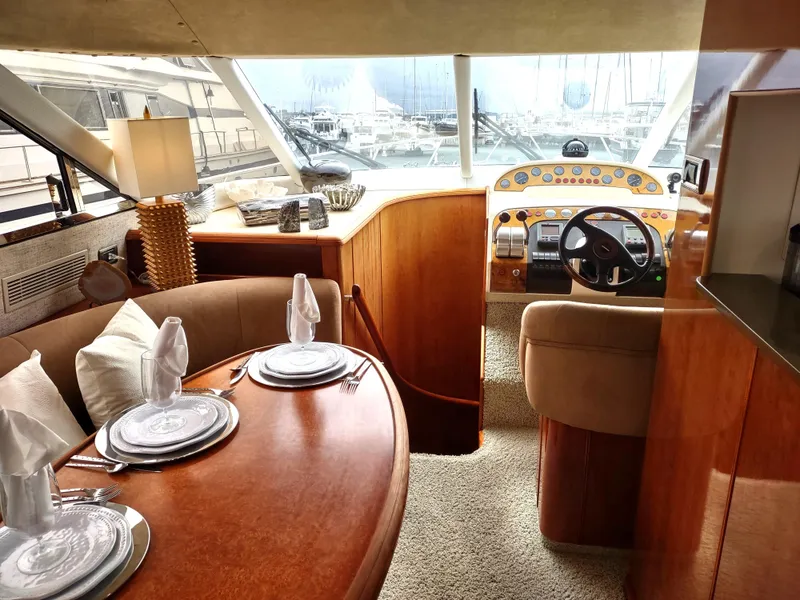 Slide: The Image of Luxurious interior of a 1997 Fairline 66 yacht with dining area and helm station. - 16