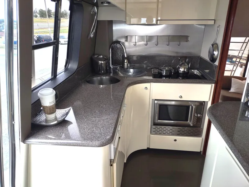 Slide: The Image of Compact kitchen in a 1997 Fairline 66 yacht with modern appliances and sleek countertops. - 27