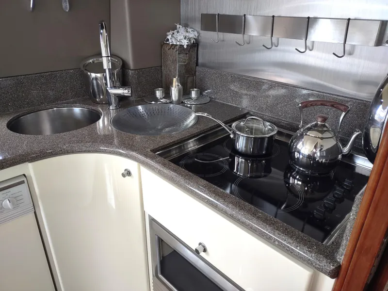 Slide: The Image of Compact kitchen area in a 1997 Fairline 66 yacht with modern appliances and sleek countertops. - 28