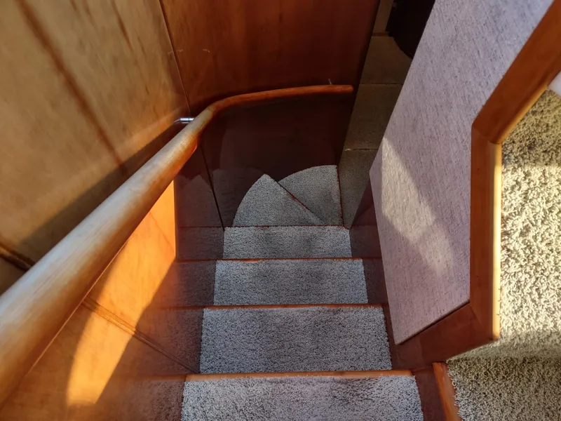 Slide: The Image of Staircase inside a 1997 Fairline 66 yacht with wooden handrails and carpeted steps. - 33