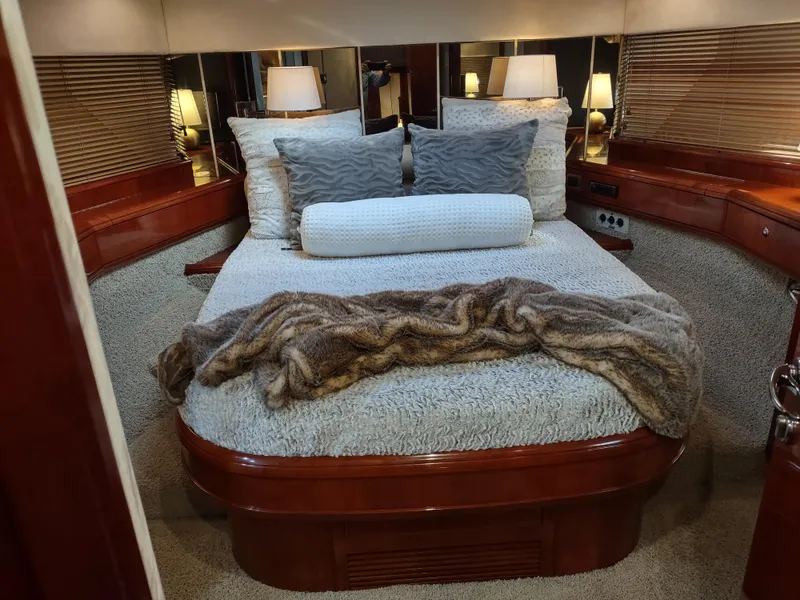 Slide: The Image of Luxurious bedroom interior of a 1997 Fairline 66 yacht with cozy bedding and ambient lighting. - 36