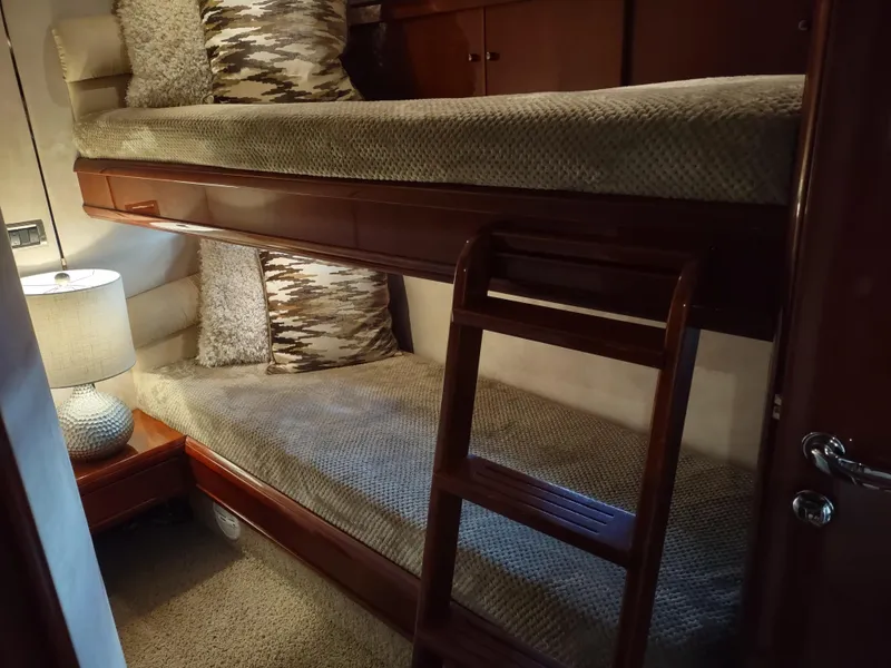 Slide: The Image of Bunk beds in a 1997 Fairline 66 yacht cabin with a wooden ladder and cozy lighting. - 38