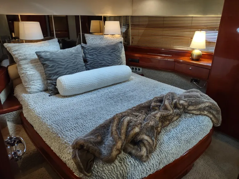 Slide: The Image of Luxurious bedroom interior of a 1997 Fairline 66 yacht with cozy bedding and ambient lighting. - 39