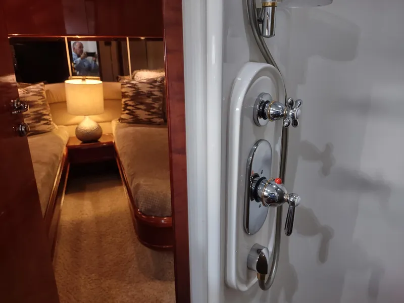 Slide: The Image of Interior of a 1997 Fairline 66 yacht showing a cozy bedroom and shower controls. - 43