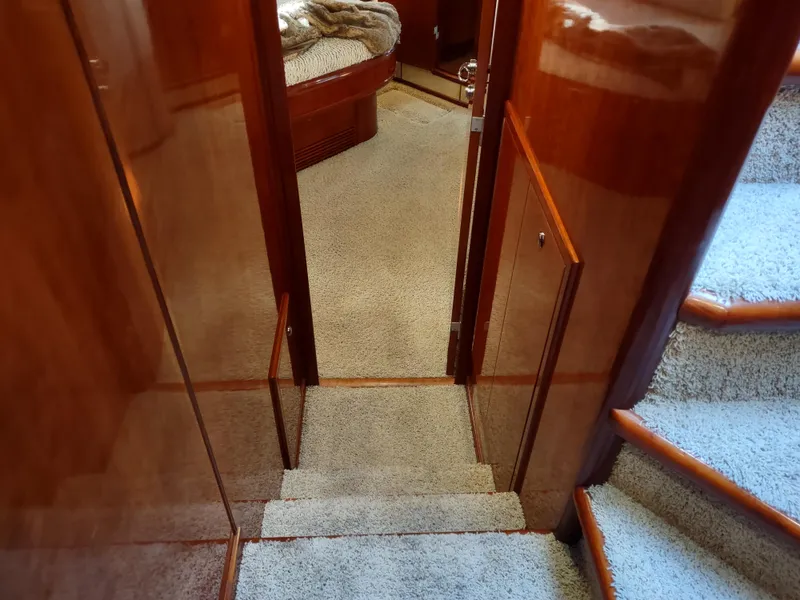 Slide: The Image of Interior hallway of a 1997 Fairline 66 yacht with carpeted stairs and wooden paneling. - 47