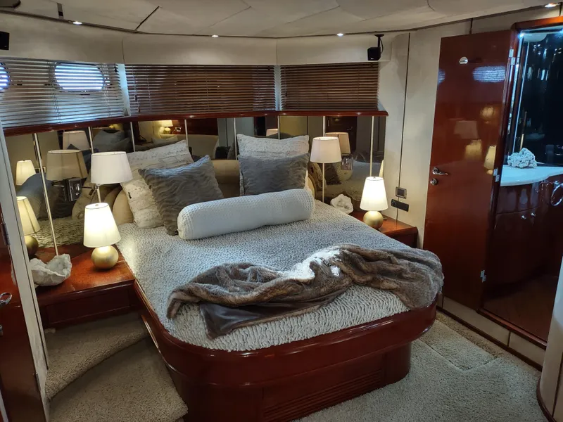 Slide: The Image of Luxurious bedroom interior of a 1997 Fairline 66 yacht with cozy bedding and ambient lighting. - 48