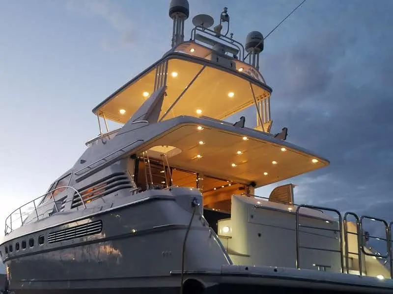 Slide: The Image of 1997 Fairline 66 yacht illuminated at dusk, showcasing its elegant design and spacious decks. - 5