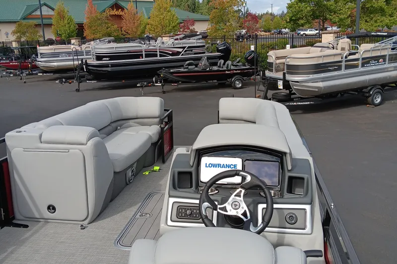 Slide: The Image of 2024 Regency 250 DL3 pontoon boat interior with steering console and seating. - 12