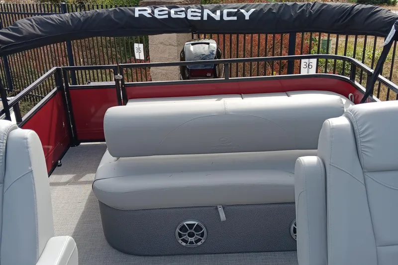 Slide: The Image of 2024 Regency 250 DL3 pontoon boat with gray seating and red accents. - 5