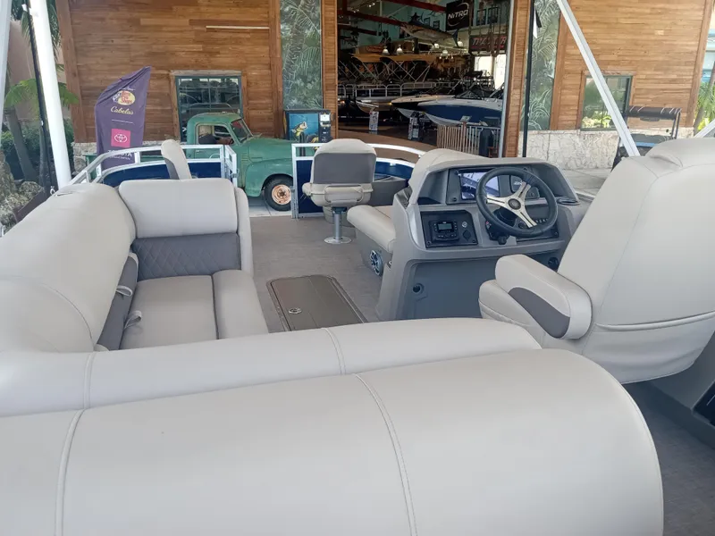 Slide: The Image of 2024 Sun Tracker Fishin' Barge 22 XP3 interior with plush seating and modern helm. - 10