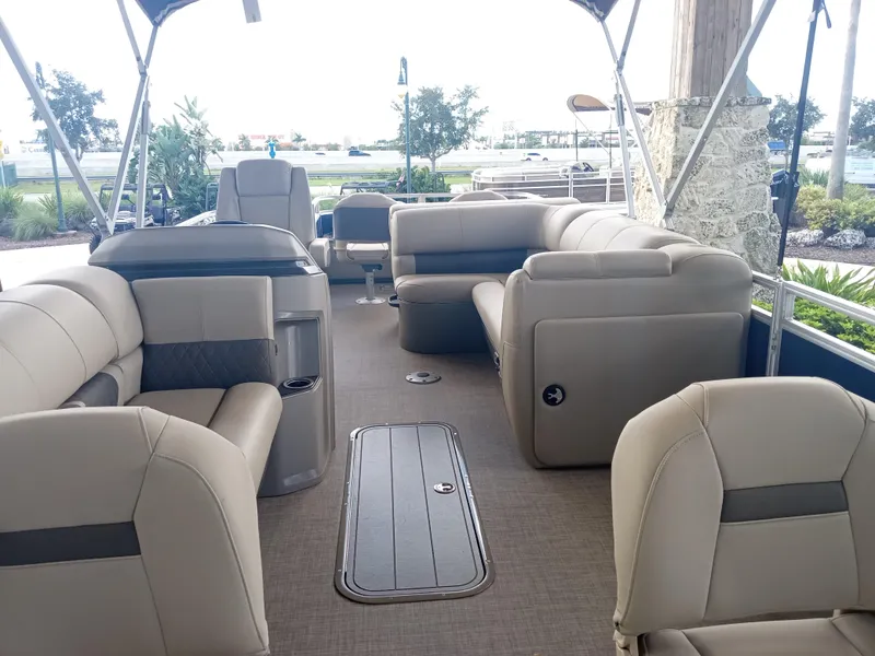 Slide: The Image of 2024 Sun Tracker Fishin' Barge 22 XP3 interior with beige seating and spacious layout. - 3