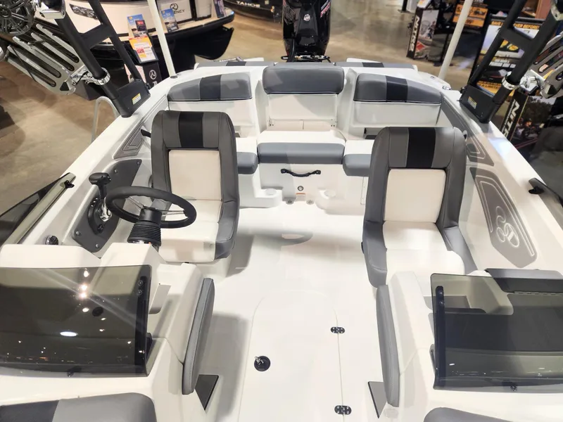 Slide: The Image of 2024 Tahoe T21 boat interior with seating and steering wheel, displayed at a showroom. - 1