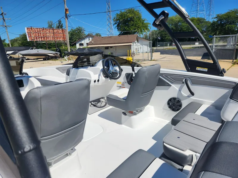 Slide: The Image of 2024 Tahoe T21 boat interior with gray seating and steering console. - 19