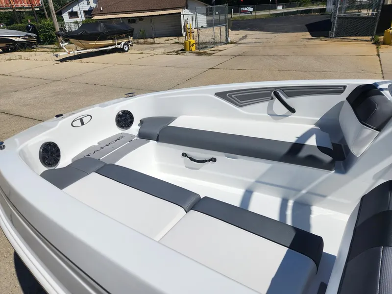 Slide: The Image of 2024 Tahoe T21 boat interior with gray and white seating, docked on a sunny day. - 21