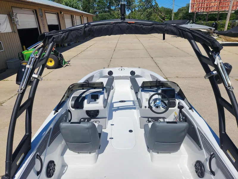 Slide: The Image of 2024 Tahoe T21 boat interior with dual consoles and gray seating. - 23
