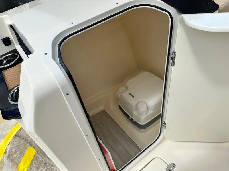 Slide: The Image of 2024 Scout 215 Dorado boat interior storage compartment with portable toilet. - 11