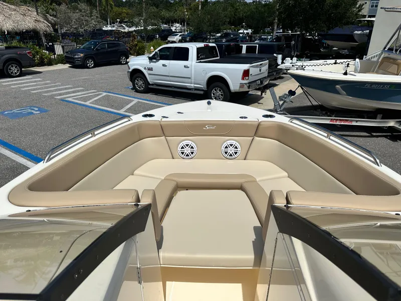 Slide: The Image of 2024 Scout 215 Dorado boat interior with beige seating in a parking lot. - 14