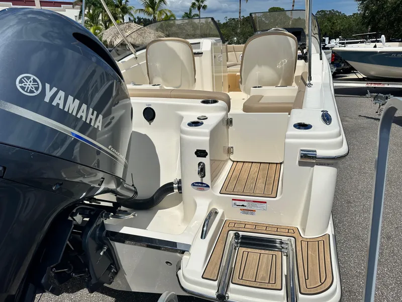 Slide: The Image of 2024 Scout 215 Dorado boat with Yamaha outboard motor, teak deck, and seating area. - 2