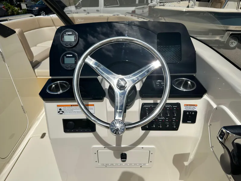 Slide: The Image of 2024 Scout 215 Dorado boat dashboard with steering wheel and control panel. - 4