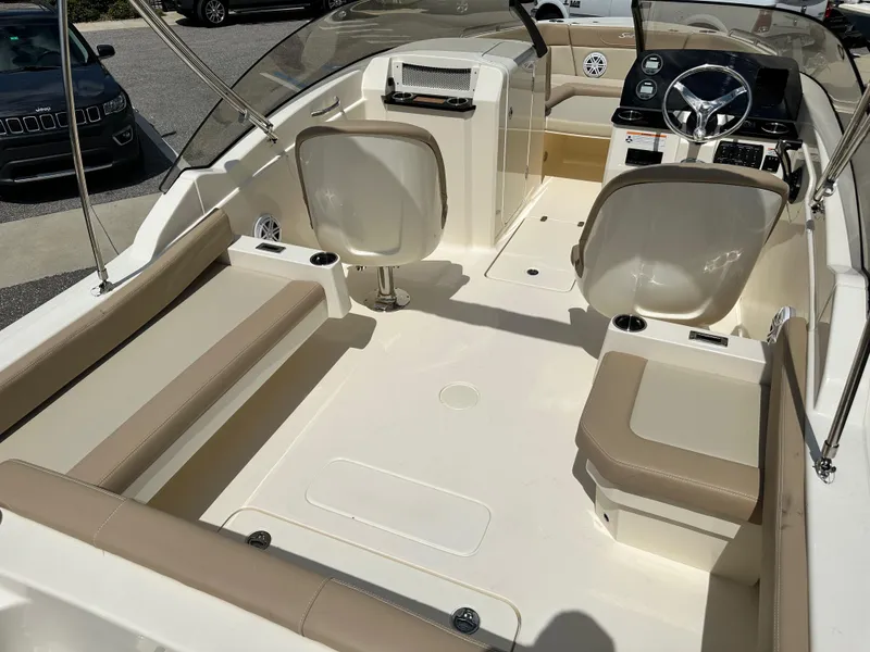 Slide: The Image of 2024 Scout 215 Dorado boat interior with beige seating and modern dashboard. - 6