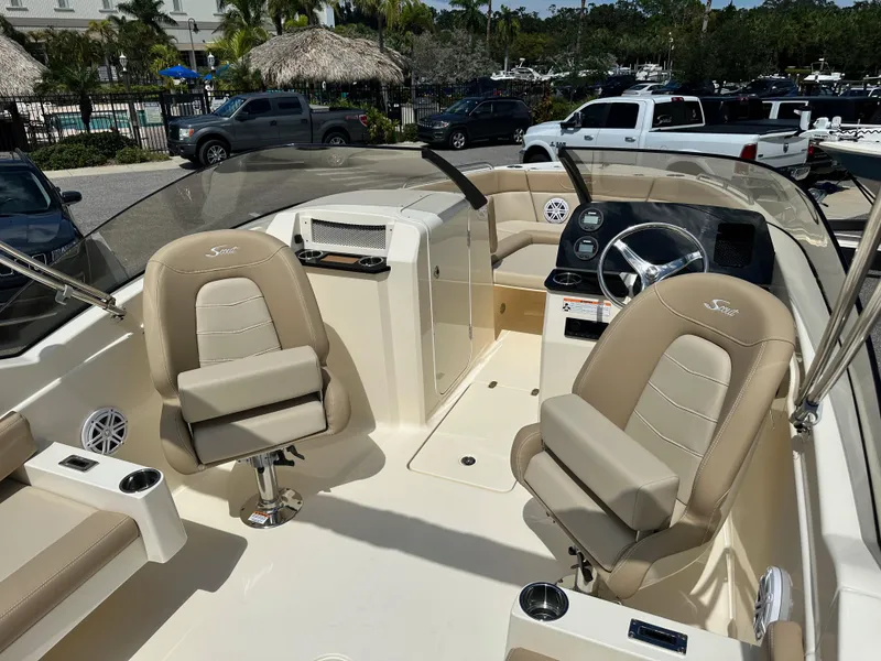 Slide: The Image of 2024 Scout 215 Dorado boat interior with beige seating and steering console. - 7