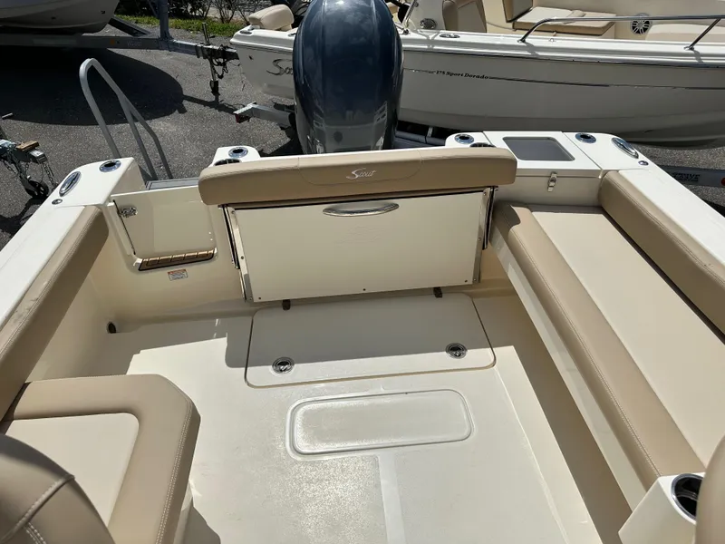 Slide: The Image of 2024 Scout 215 Dorado boat interior with beige seating and outboard motor. - 8