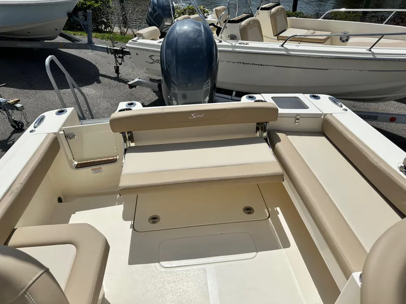 Slide: The Image of 2024 Scout 215 Dorado boat interior with beige seating and outboard motor. - 9