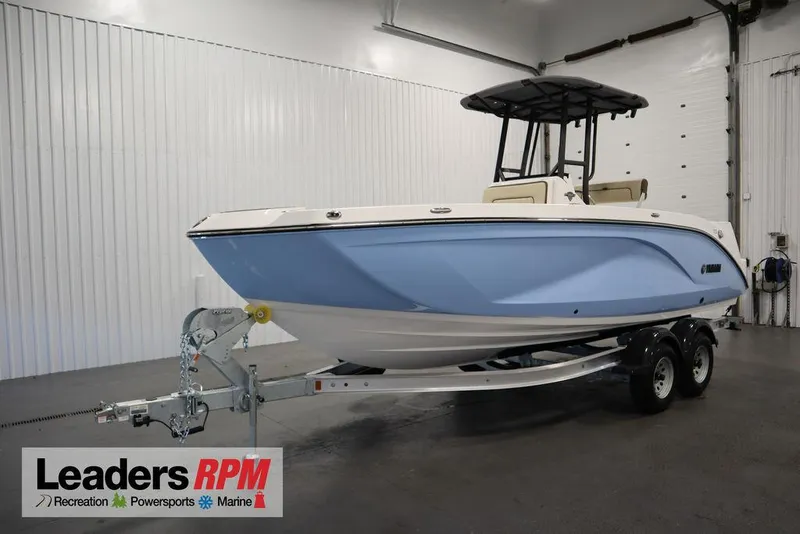 Slide: The Image of 2024 Yamaha Boats 222 FSH Sport in showroom, blue hull, on trailer. - 1