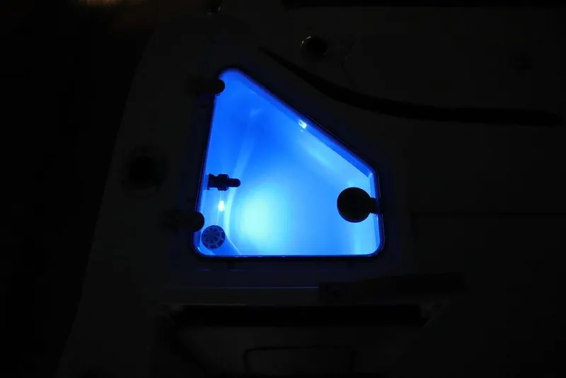 Slide: The Image of 2024 Yamaha Boats 222 FSH Sport illuminated compartment with blue LED lighting. - 13