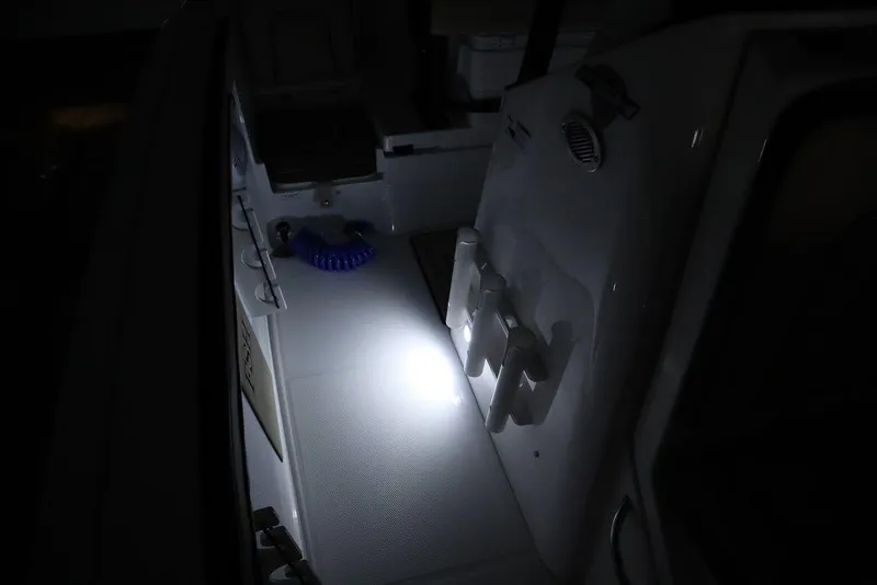 Slide: The Image of 2024 Yamaha Boats 222 FSH Sport interior with illuminated deck and storage compartments. - 17