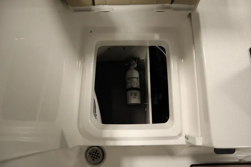 Slide: The Image of 2024 Yamaha Boats 222 FSH Sport storage compartment with fire extinguisher. - 33