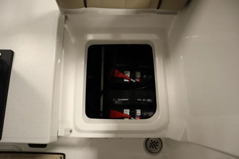 Slide: The Image of 2024 Yamaha Boats 222 FSH Sport battery compartment with dual batteries. - 34
