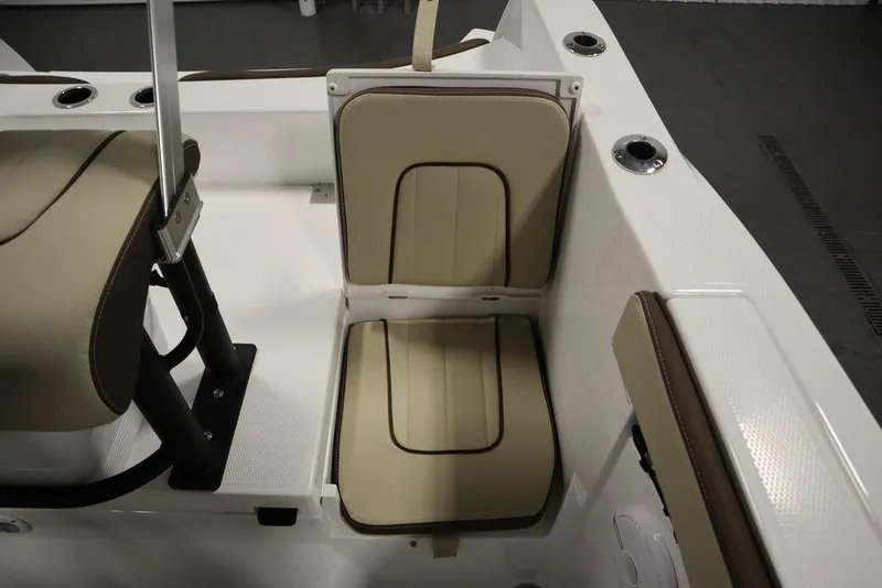 Slide: The Image of 2024 Yamaha Boats 222 FSH Sport interior seating, beige cushions, sleek design. - 35