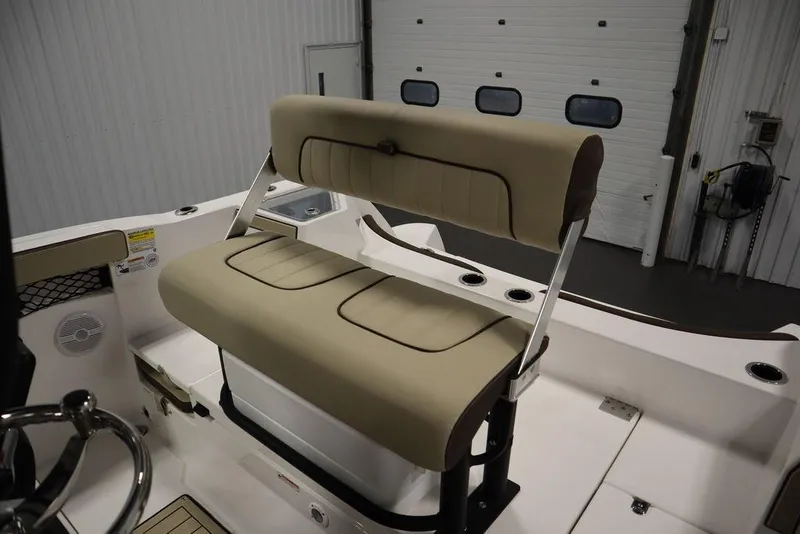 Slide: The Image of 2024 Yamaha Boats 222 FSH Sport interior with beige seating in a garage setting. - 38